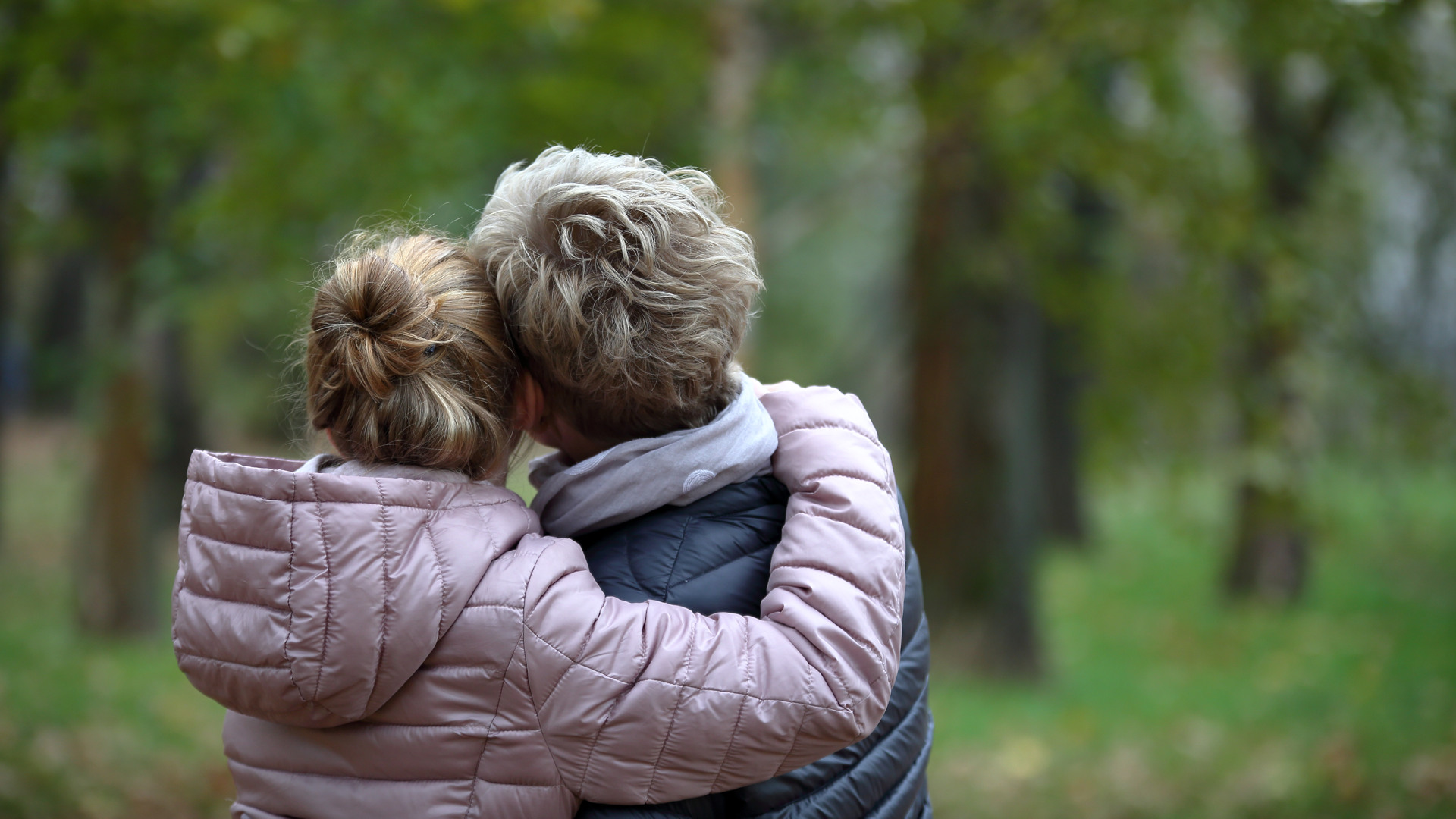 Mamma och dotter som kramas i skogen